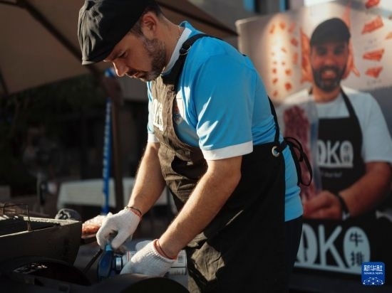 7月19日，在蕪湖古城，馬丁在當(dāng)天舉行的啤酒節(jié)上制作牛排。新華社發(fā)（繆雨晨 攝）