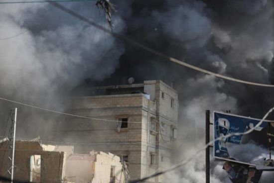 7月21日，在加沙地帶中部的努賽賴特難民營，遭以軍空襲的建筑冒出滾滾濃煙。新華社發(fā)（馬爾萬·達(dá)烏德攝）