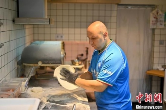 近日，韋榮耀在自家披薩小店內(nèi)忙活。俞靖 攝