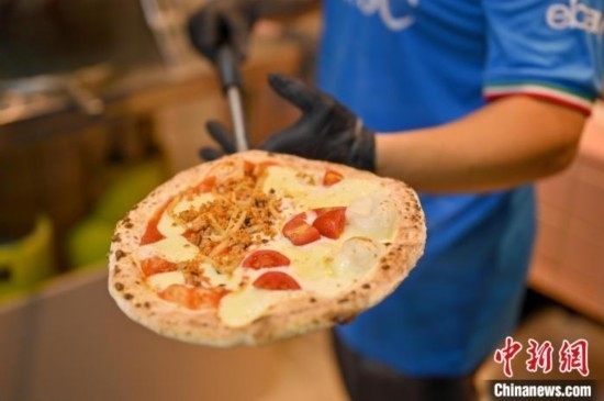 近日，韋榮耀展示他制作的“老友味”披薩。 俞靖 攝