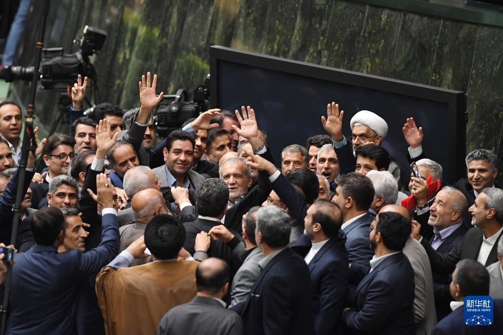 7月30日，在伊朗德黑蘭的伊朗議會(huì)，佩澤希齊揚(yáng)（中）離開總統(tǒng)就職典禮現(xiàn)場(chǎng)時(shí)揮手致意。新華社記者 沙達(dá)提 攝