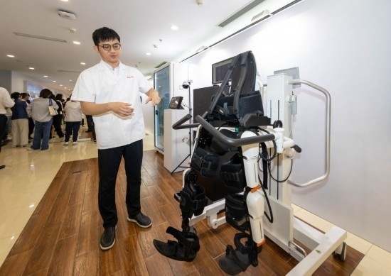 2024年5月24日，在位于上海市嘉定區(qū)的上海交通大學(xué)醫(yī)學(xué)院附屬瑞金醫(yī)院腫瘤質(zhì)子中心，工作人員介紹由瑞金醫(yī)院醫(yī)生和醫(yī)療公司共同研發(fā)的用于恢復(fù)患者下肢的醫(yī)療機(jī)器人。新華社記者 王翔 攝