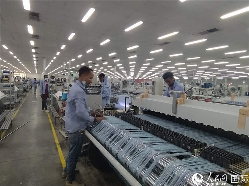 無錫金茂埃塞面料廠車間內(nèi)，當(dāng)?shù)毓と苏谝唤z不茍地作業(yè)。人民網(wǎng)記者 黃培昭攝