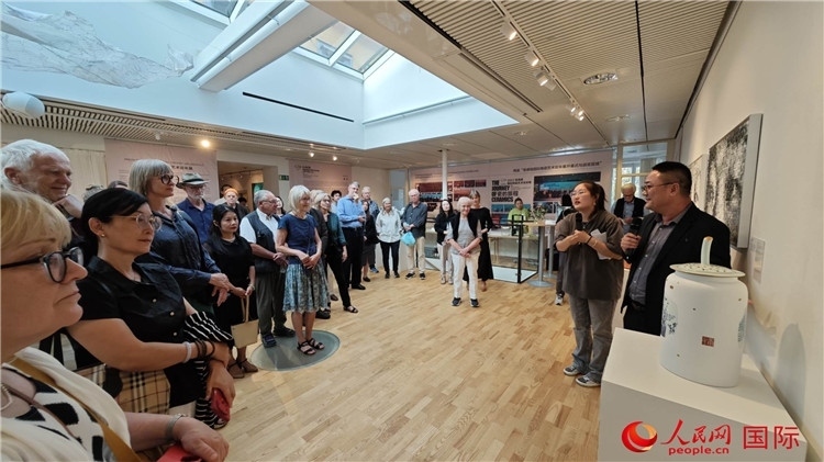 參展人、景德鎮(zhèn)陶瓷大學(xué)美術(shù)學(xué)院副院長(zhǎng)邵長(zhǎng)宗（右一）向來(lái)賓介紹參展作品。人民網(wǎng)記者 殷淼攝