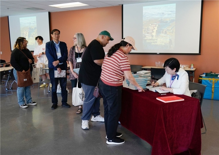 作者顧春芳在活動現(xiàn)場簽名贈書。羅先勇攝