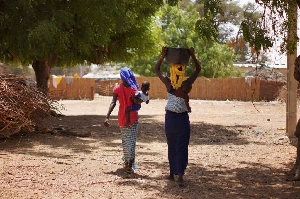 2023年3月20日，在塞內(nèi)加爾久爾貝勒區(qū)的泰內(nèi)富勒村，村民將取到的水運回家。新華社記者 王子正 攝