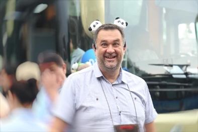 參訪熊貓谷前，塞爾維亞“一帶一路”研究所所長(zhǎng)博揚(yáng)·拉利奇戴上熊貓頭飾。（李佩藺 攝）