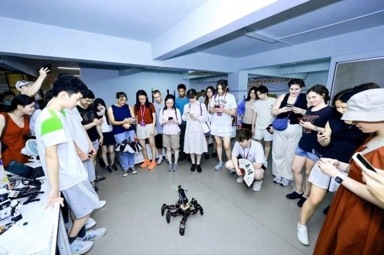8月25日，中外青年在浙江杭州觀看機(jī)器人表演。新華社發(fā)（清華大學(xué)供圖）