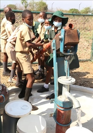 △2021年11月，在津巴布韋南馬塔貝萊蘭省省會(huì)關(guān)達(dá)的塞農(nóng)多小學(xué)，學(xué)生從中國援建水井里打水。