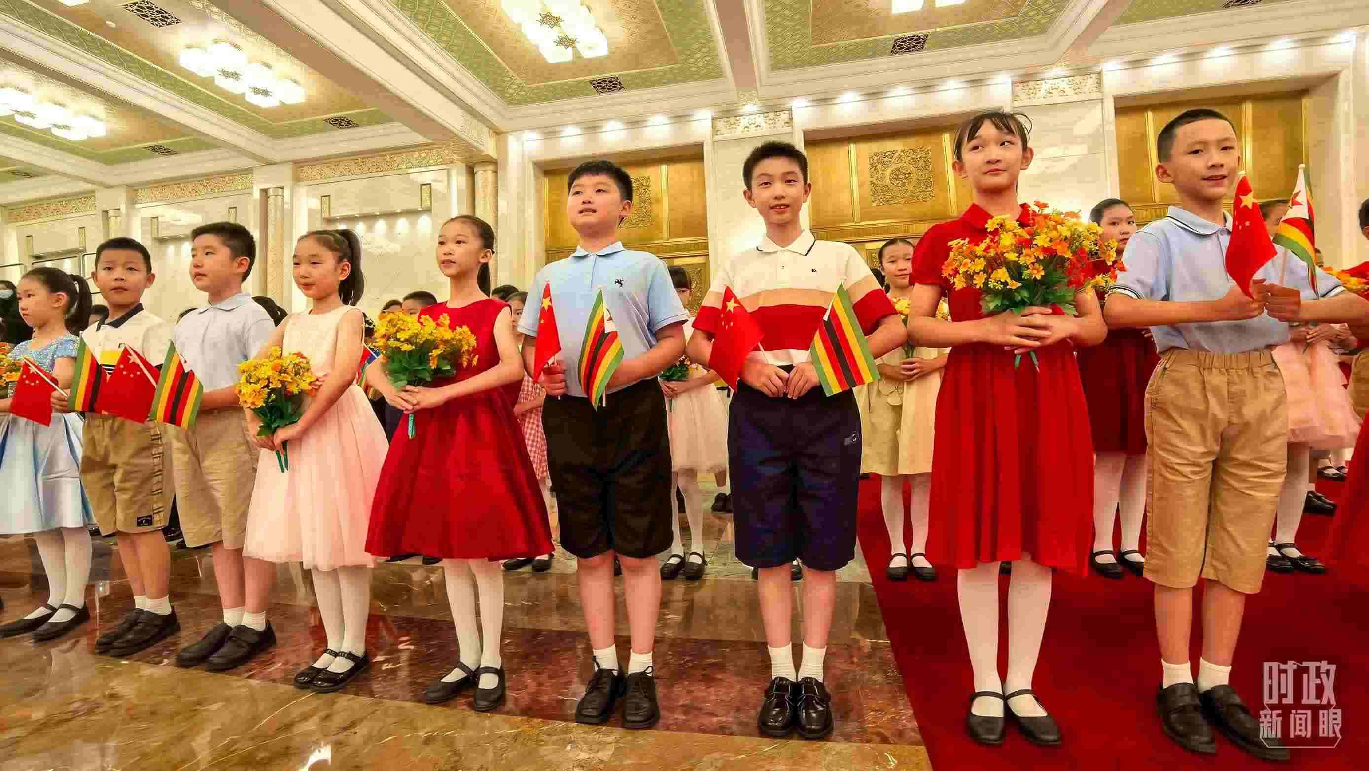 △現(xiàn)場歡迎津巴布韋總統(tǒng)訪華的青少年。（總臺央視記者鐘銳拍攝）