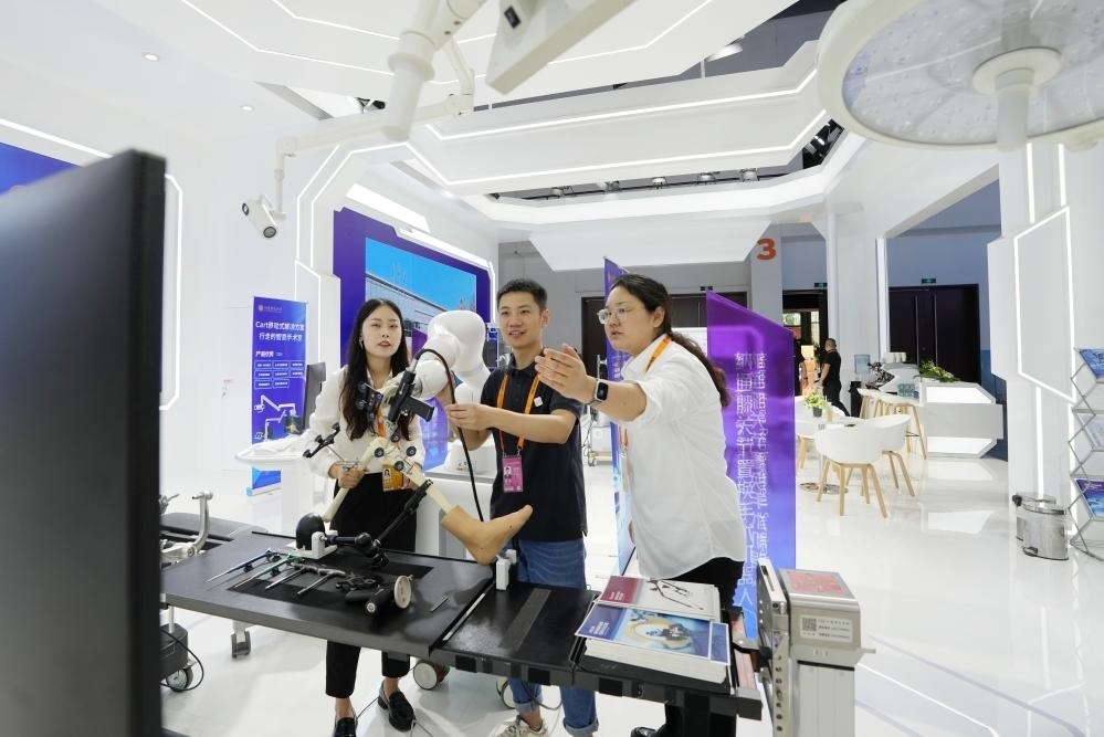 9月11日，一位媒體記者（中）在2024年服貿(mào)會(huì)國家會(huì)議中心會(huì)場體驗(yàn)北京納通科技集團(tuán)有限公司的膝關(guān)節(jié)置換手術(shù)機(jī)器人。新華社記者鞠煥宗 攝