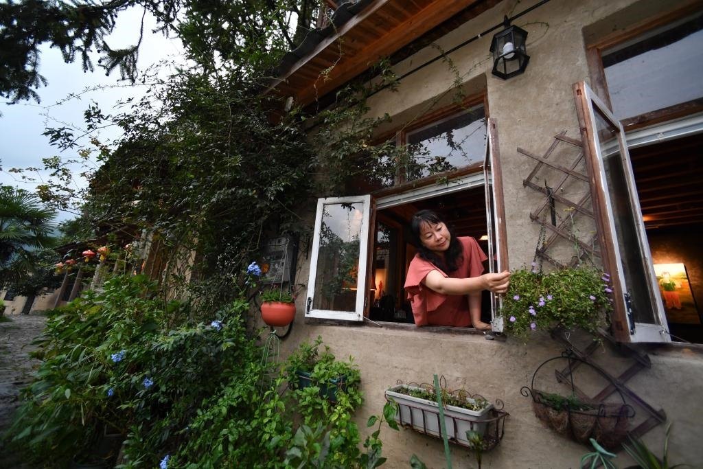 8月29日，在福建省屏南縣熙嶺鄉(xiāng)，龍?zhí)洞濉靶麓迕瘛泵泛暝诖蚶碜约航?jīng)營的民宿外墻裝飾花盆。新華社記者姜克紅 攝