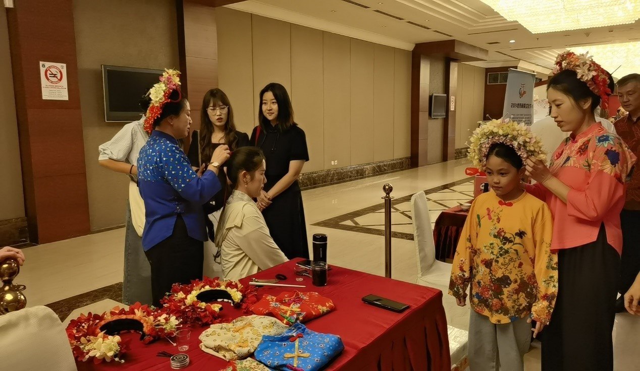 阿拉扎大學孔子學院志愿者老師向傳承人學習簪花圍。阿拉扎大學孔子學院供圖