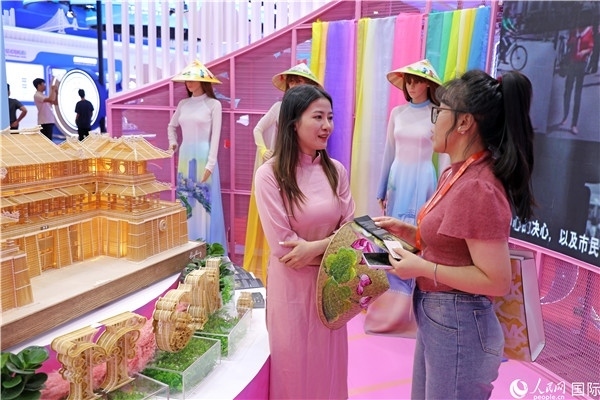 參觀者在東博會(huì)越南展區(qū)同工作人員咨詢交談。人民網(wǎng)記者 趙益普攝