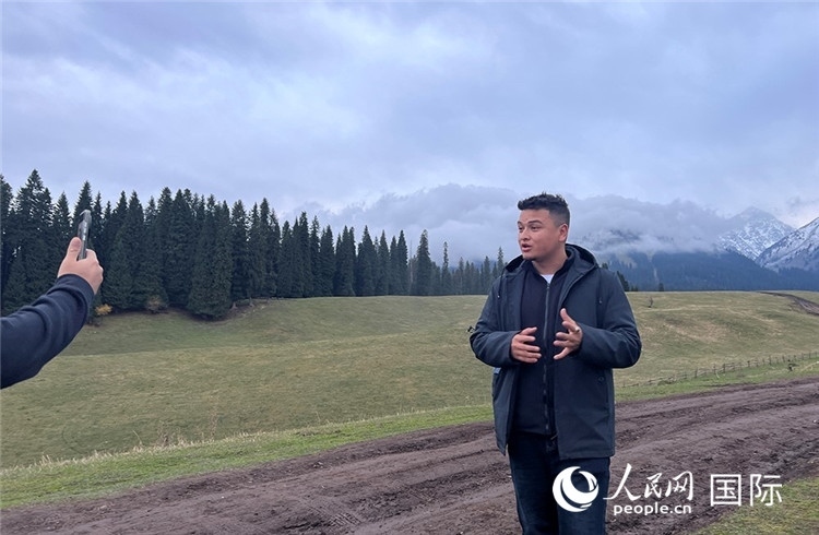 在庫爾德寧，吾買爾江被雪山美景震撼，即興錄制了短視頻作品。人民網(wǎng)記者曾書柔攝