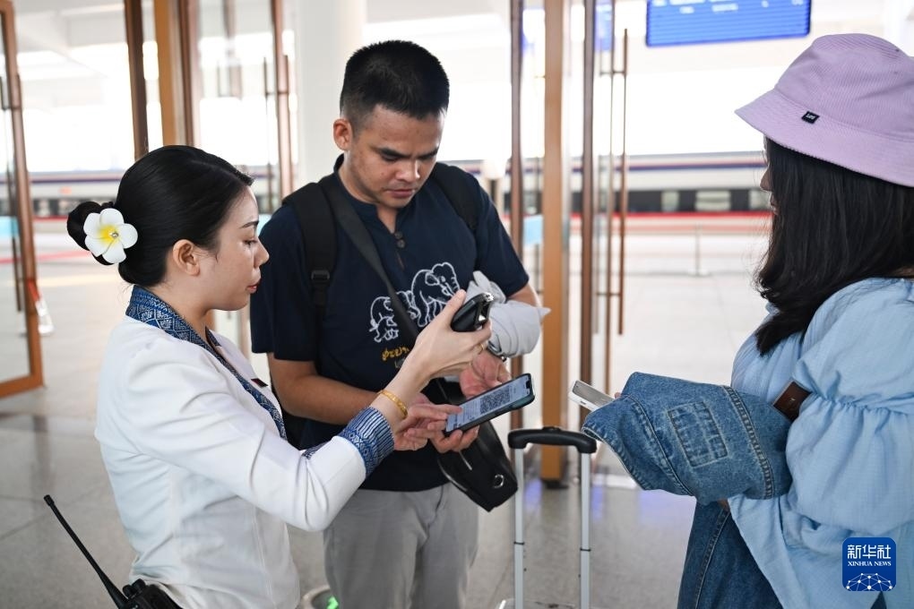 10月12日，在老撾萬(wàn)象中老鐵路萬(wàn)象站，工作人員檢驗(yàn)乘客車(chē)票。新華社記者 程一恒 攝
