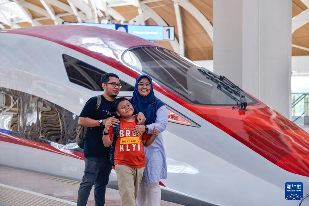 4月17日，在印度尼西亞雅加達(dá)哈利姆站站臺(tái)，乘客和雅萬(wàn)高鐵高速動(dòng)車(chē)組列車(chē)合影。新華社記者 徐欽 攝