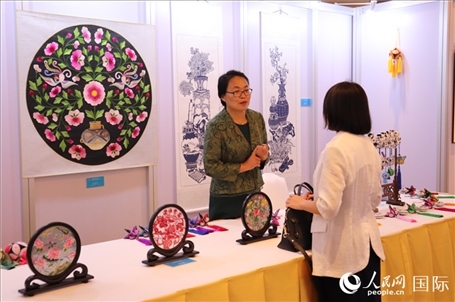 青海非遺文化傳承人向嘉賓介紹展品。人民網(wǎng)實習生姚欣可攝