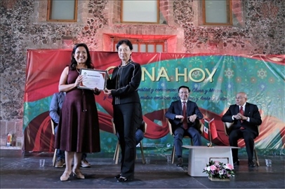 李雅芳向加比拉爾·塞迪略授予“拉美分社榮譽(yù)員工”稱號(hào)。主辦方供圖