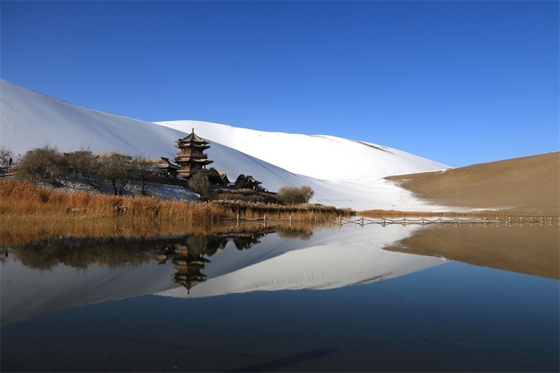 鳴沙山月牙泉景區(qū)雪景。敦煌市委宣傳部供圖，張曉亮攝