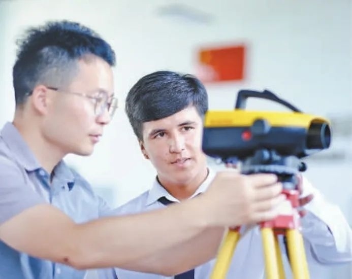 在塔吉克斯坦首都杜尚別的魯班工坊，來自天津城市建設(shè)管理職業(yè)技術(shù)學(xué)院的老師（左）為當(dāng)?shù)貙W(xué)生提供指導(dǎo)。新華社記者 鄭開君 攝