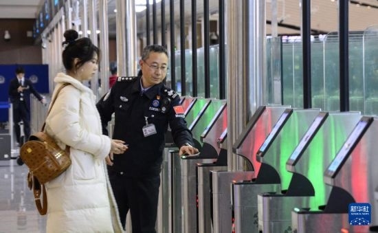 1月2日，大興機(jī)場(chǎng)邊檢站警察指導(dǎo)旅客使用自助出境設(shè)備。新華社記者 李欣 攝