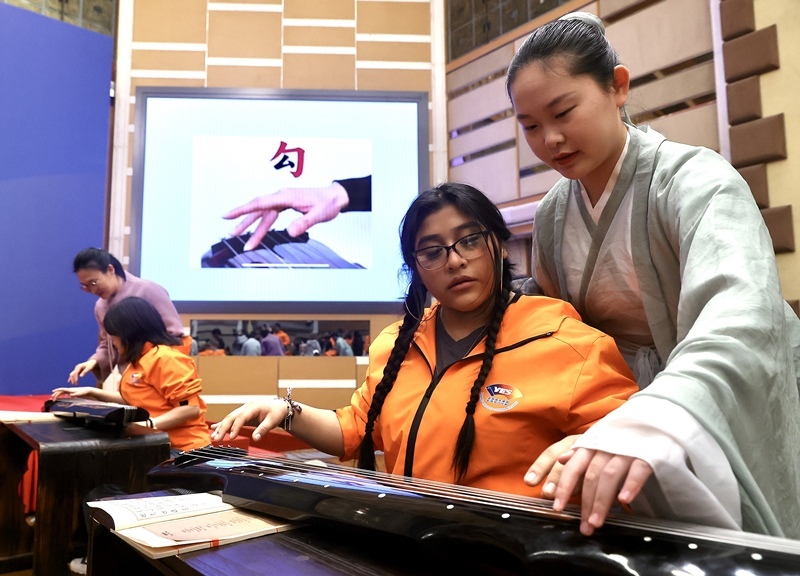 2024年3月20日，美國華盛頓州中學(xué)生代表團(tuán)北京大學(xué)交流活動在北京大學(xué)英杰交流中心舉行。圖為來自華盛頓州的中學(xué)生體驗古琴。