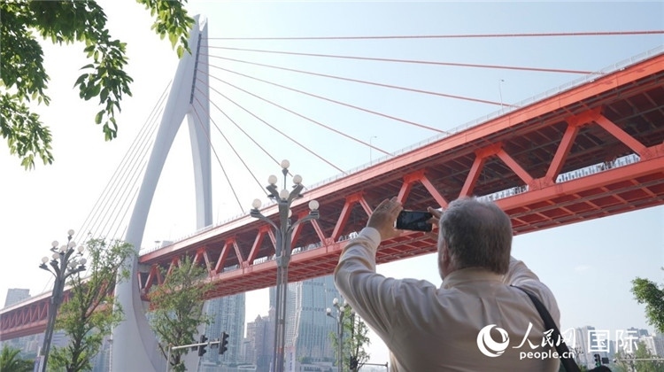 軻寶華“打卡”重慶東水門長江大橋。人民網(wǎng)記者 蘇纓翔攝
