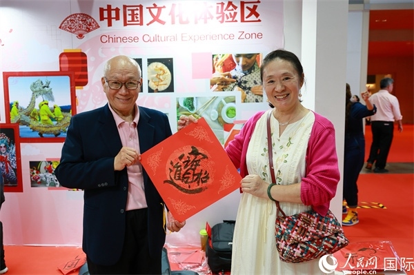 本地觀眾在中國文化體驗(yàn)區(qū)展示書法作品。人民網(wǎng)記者 白元琪攝