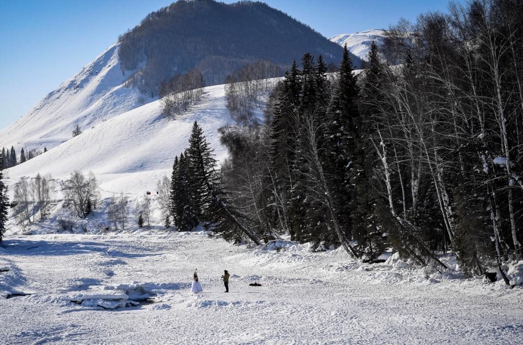 2024年2月5日，兩名游客在新疆阿勒泰地區(qū)布爾津縣禾木村拍照。新華社記者 馬鍇 攝