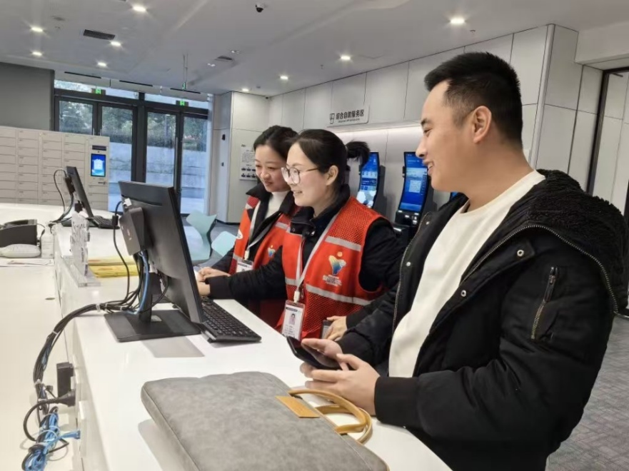 工作人員幫助企業(yè)辦理遷移申請網(wǎng)上填報。圖片來源：浙江衢州市市場監(jiān)督管理局