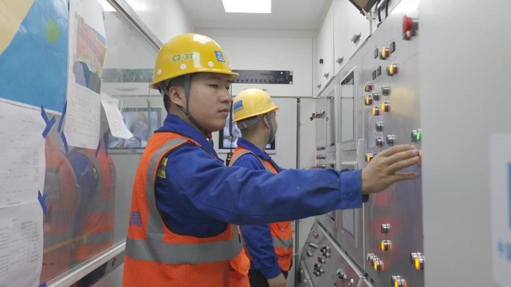 盾構(gòu)司機(jī)何曉波在駕駛室內(nèi)調(diào)試盾構(gòu)機(jī)參數(shù)。（劉芬攝）