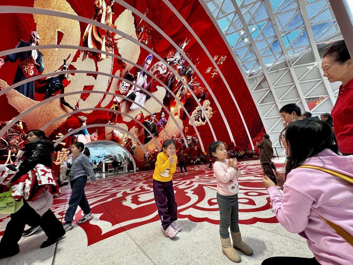 乙巳蛇年春節(jié)期間，影迷在《哪吒之魔童鬧?！肪薹?bào)前拍照打卡。