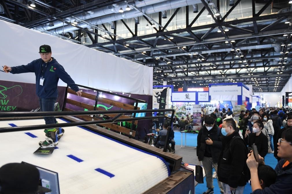2023年2月11日，參觀者在展會(huì)上了解一款模擬滑雪設(shè)備。當(dāng)日，2023亞洲運(yùn)動(dòng)用品與時(shí)尚展在國家會(huì)議中心拉開帷幕。新華社記者 張晨霖 攝