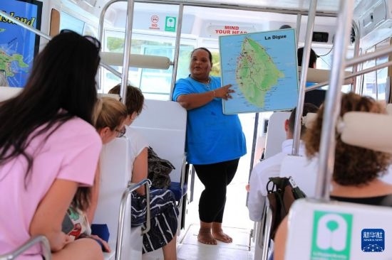 3月15日，一名導(dǎo)游在游艇上為游客介紹塞舌爾拉迪格島。新華社記者 董江輝 攝