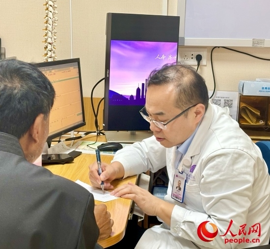 路桂軍接診時為患者寫下用藥提示。人民網記者 金慧慧攝