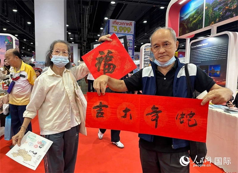 2025蛇年春節(jié)，泰國市民展示他們領到的華人手寫春聯(lián)。人民網(wǎng)記者 簡承淵攝