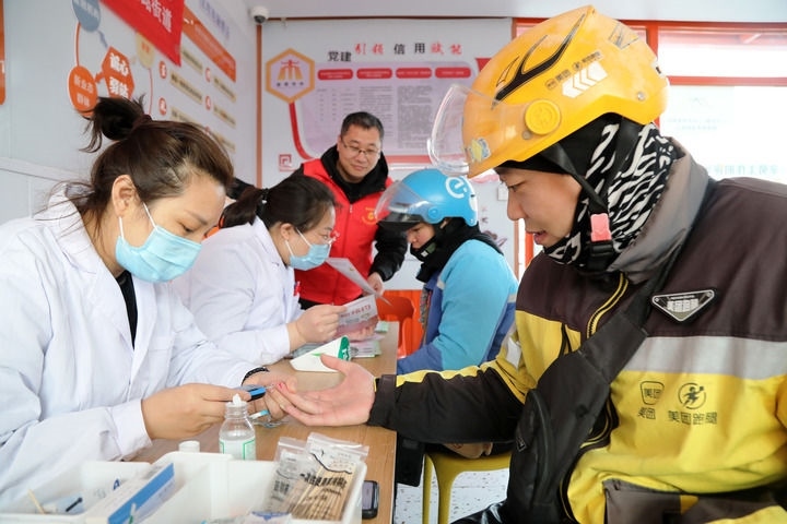 2025年3月5日，志愿者在山東省棗莊市市中區(qū)一工會驛站為外賣員免費測量血糖。新華社發(fā)（王海楠攝）