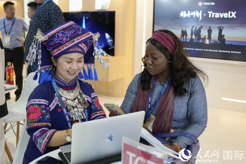 來(lái)自廣西的旅游業(yè)者同客戶交流。人民網(wǎng)塔里克·易卜拉欣攝