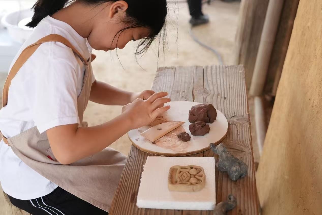 游客制作良渚特色陶藝品。良渚博物院供圖