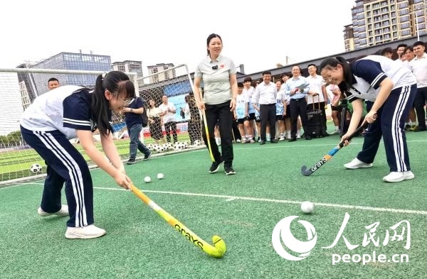 陳朝霞（中）指導(dǎo)學(xué)生體驗(yàn)曲棍球。 人民網(wǎng)記者 楊磊攝