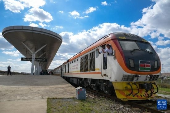 5月31日，在蒙內(nèi)鐵路內(nèi)羅畢站，機(jī)車駕駛員蔣立平（右）和博爾在即將開(kāi)往蒙巴薩的E2次列車上揮手致意。新華社記者 楊光 攝